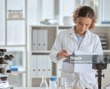 Shot of a young scientist going through paperwork in a lab Shot of a young scientist going through paperwork in a lab